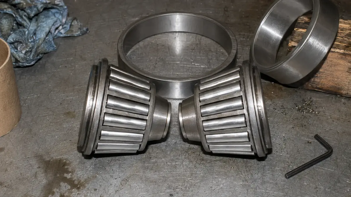 Two tapered roller bearings dismantled into cones and cups with their tapers opposed, the arrangement that gives the internally induced axial load somewhere to react