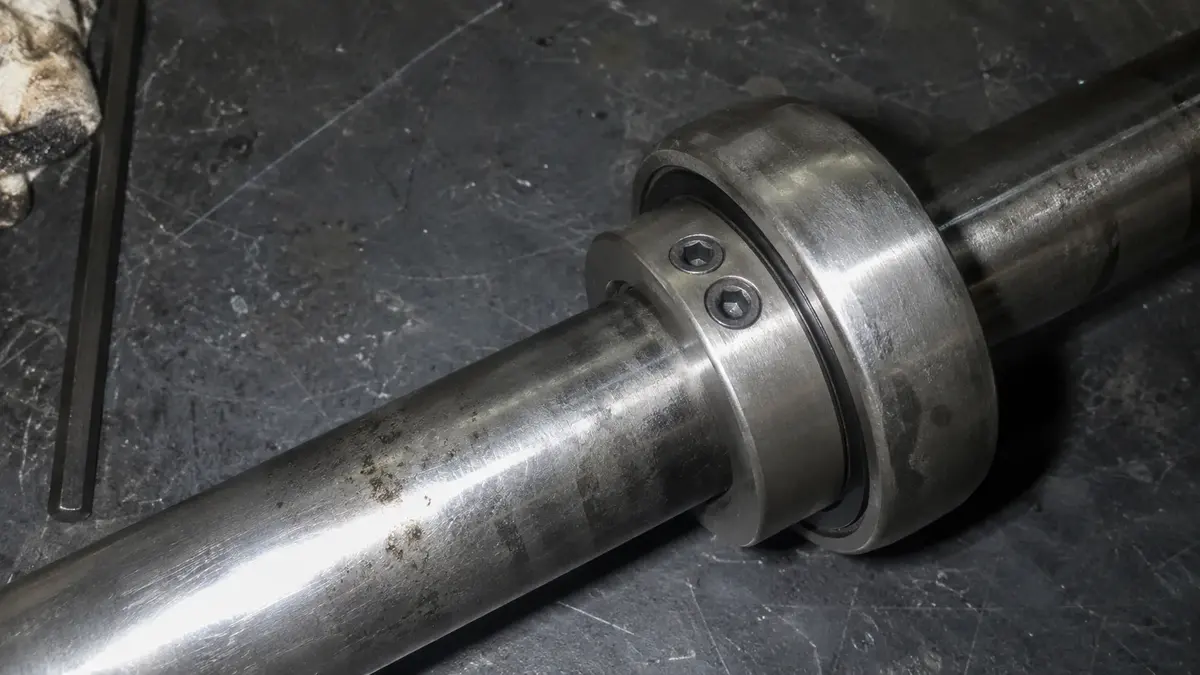 Two hex-socket set screws seated at a narrow included angle in the extended inner ring of a pillow block insert bearing, the set-screw locking method that clamps the shaft at two contact points